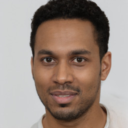 Joyful black young-adult male with short  brown hair and brown eyes