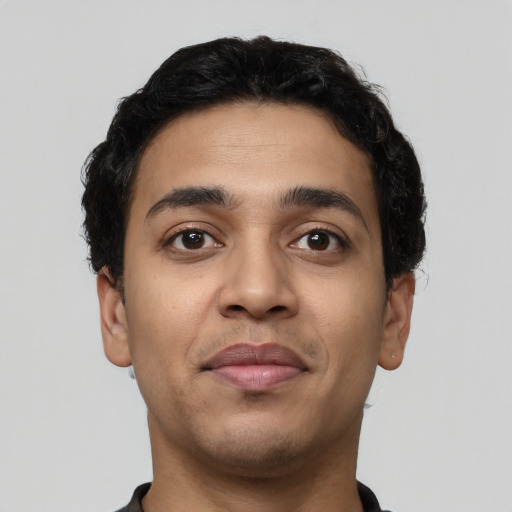 Joyful latino young-adult male with short  brown hair and brown eyes