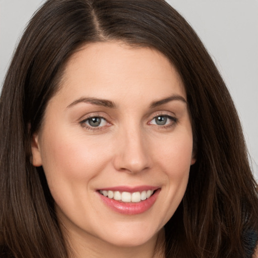 Joyful white young-adult female with long  brown hair and brown eyes