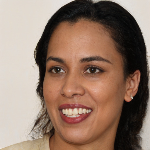 Joyful latino young-adult female with medium  brown hair and brown eyes