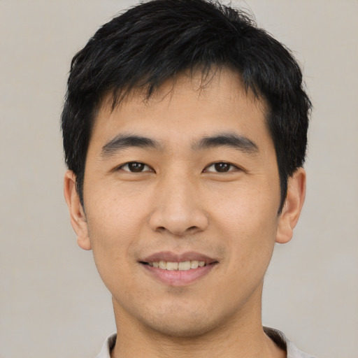 Joyful asian young-adult male with short  black hair and brown eyes