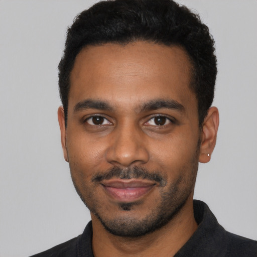 Joyful black young-adult male with short  black hair and brown eyes