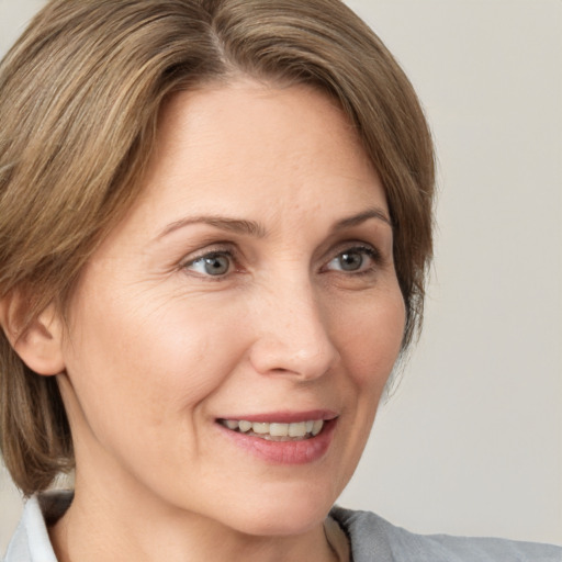 Joyful white adult female with medium  brown hair and grey eyes