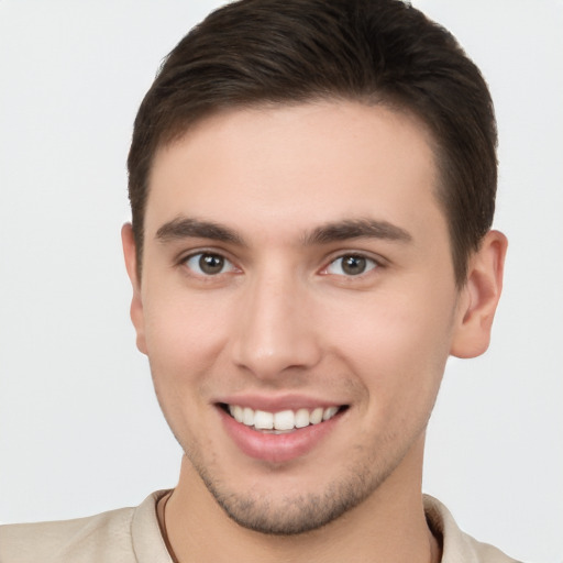 Joyful white young-adult male with short  brown hair and brown eyes