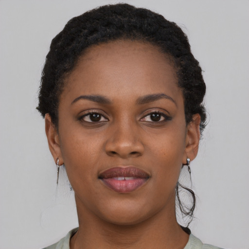 Joyful black young-adult female with short  black hair and brown eyes