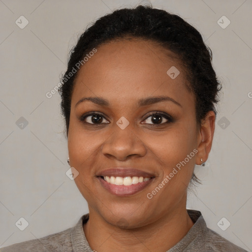 Joyful black young-adult female with short  black hair and brown eyes