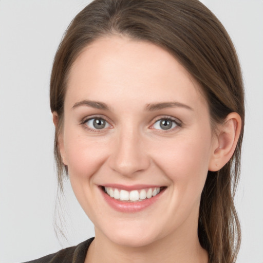 Joyful white young-adult female with long  brown hair and grey eyes