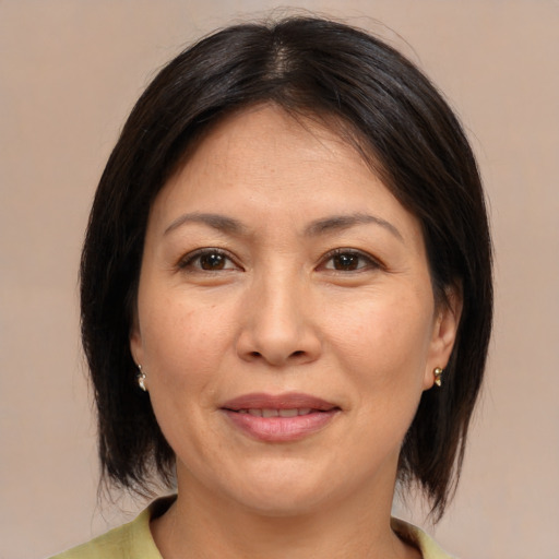Joyful asian adult female with medium  brown hair and brown eyes