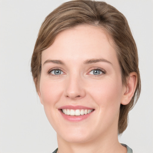 Joyful white young-adult female with medium  brown hair and green eyes