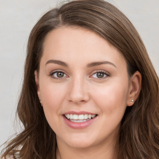 Joyful white young-adult female with long  brown hair and grey eyes