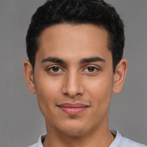 Joyful latino young-adult male with short  brown hair and brown eyes