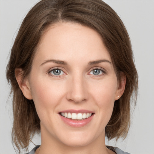 Joyful white young-adult female with medium  brown hair and grey eyes