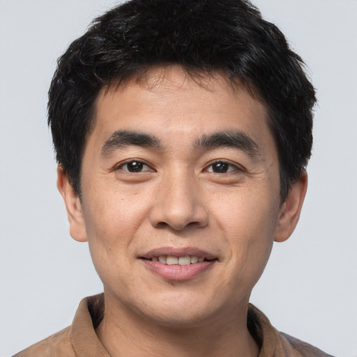 Joyful white young-adult male with short  black hair and brown eyes