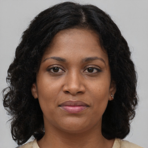 Joyful black young-adult female with long  brown hair and brown eyes