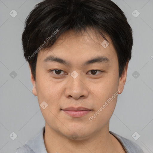 Joyful asian young-adult male with short  brown hair and brown eyes