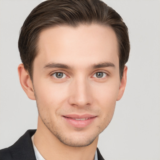 Joyful white young-adult male with short  brown hair and grey eyes