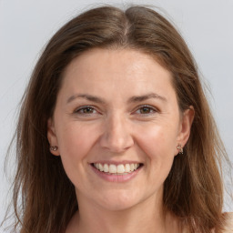 Joyful white adult female with long  brown hair and grey eyes