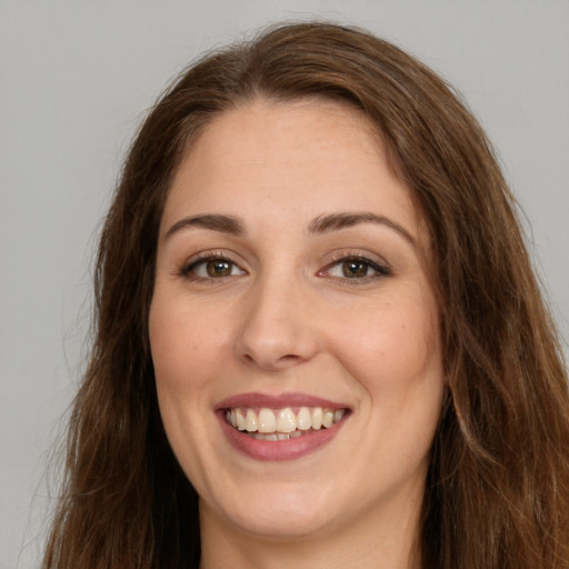 Joyful white young-adult female with long  brown hair and green eyes