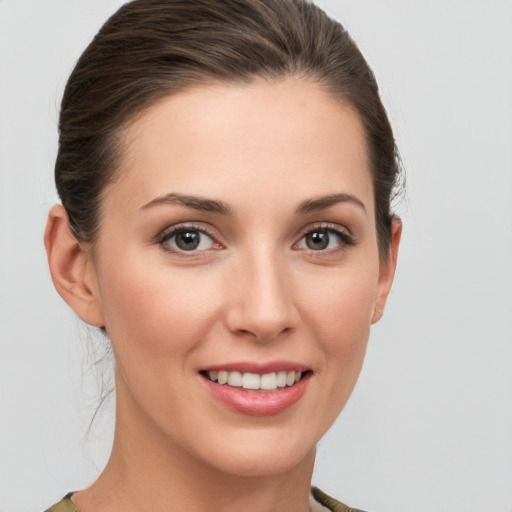 Joyful white young-adult female with medium  brown hair and grey eyes