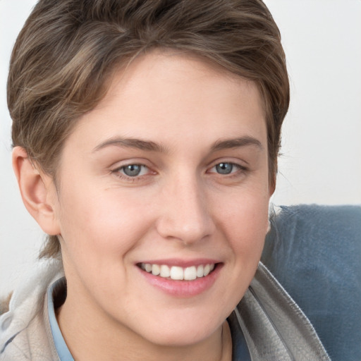 Joyful white young-adult female with short  brown hair and grey eyes