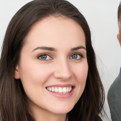 Joyful white young-adult female with long  brown hair and brown eyes