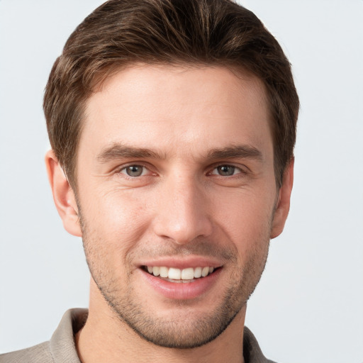 Joyful white young-adult male with short  brown hair and grey eyes