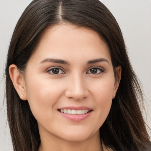 Joyful white young-adult female with long  brown hair and brown eyes