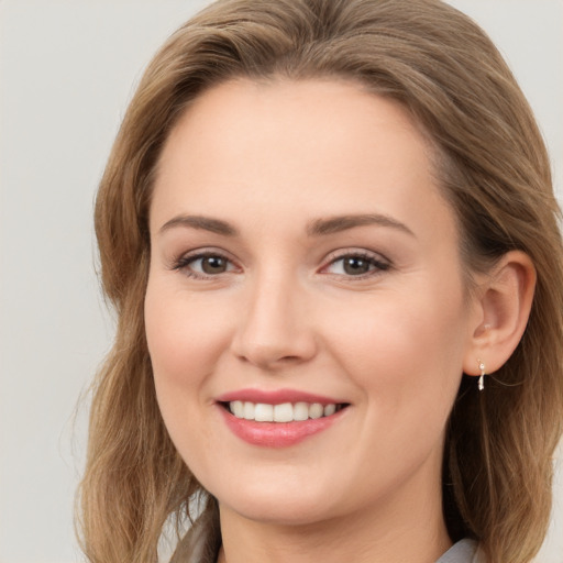 Joyful white young-adult female with long  brown hair and brown eyes