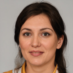 Joyful white adult female with medium  brown hair and brown eyes