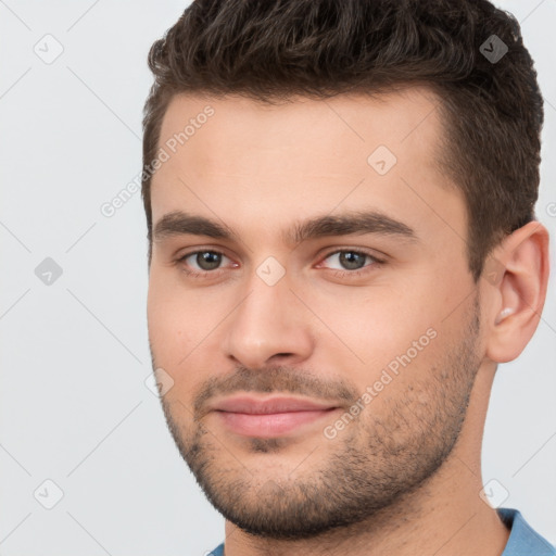 Joyful white young-adult male with short  brown hair and brown eyes