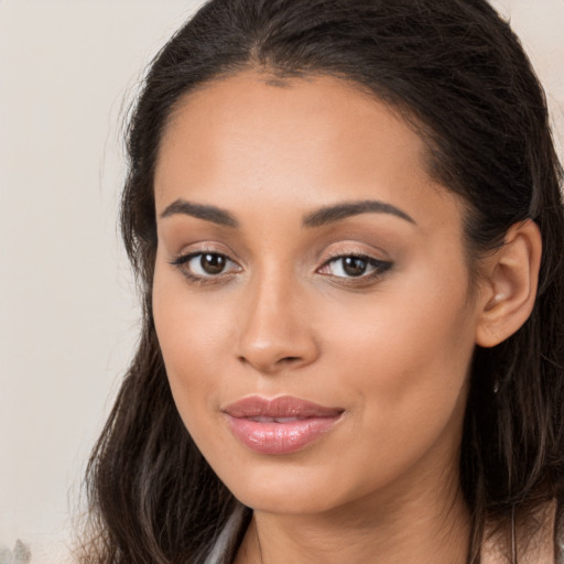 Joyful latino young-adult female with long  brown hair and brown eyes