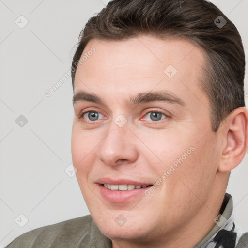 Joyful white young-adult male with short  brown hair and grey eyes