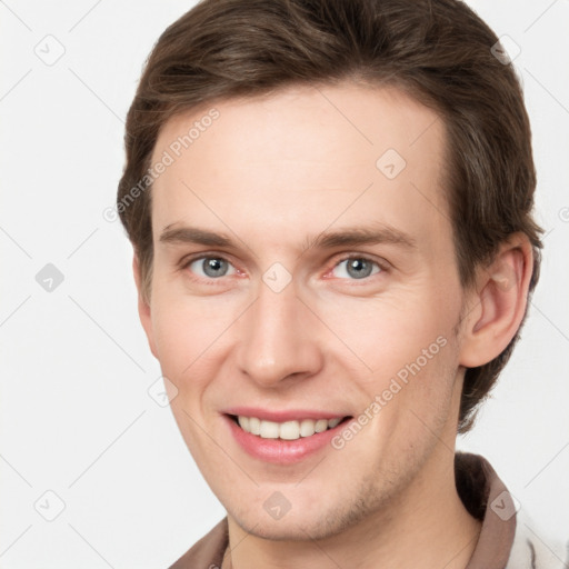 Joyful white young-adult male with short  brown hair and grey eyes