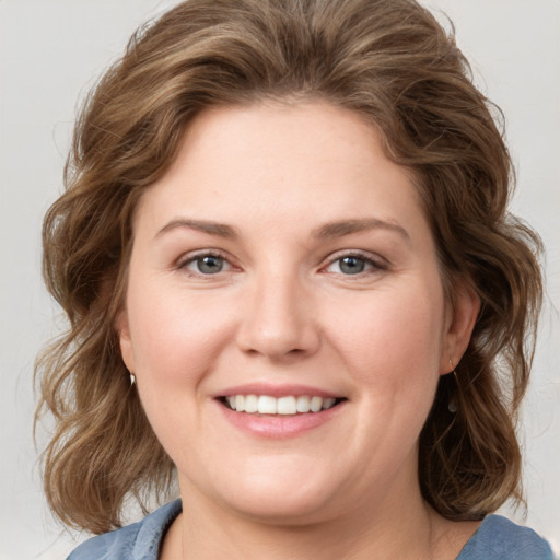 Joyful white young-adult female with medium  brown hair and blue eyes