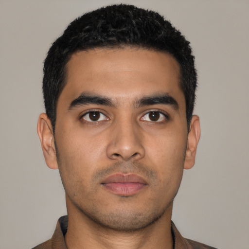 Joyful latino young-adult male with short  black hair and brown eyes