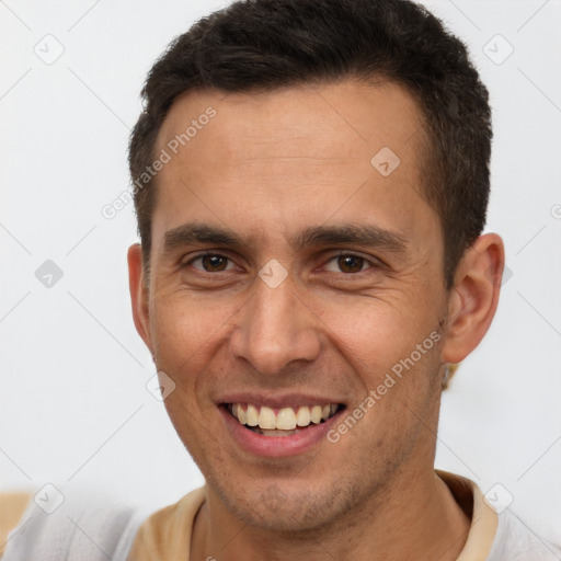 Joyful white adult male with short  brown hair and brown eyes