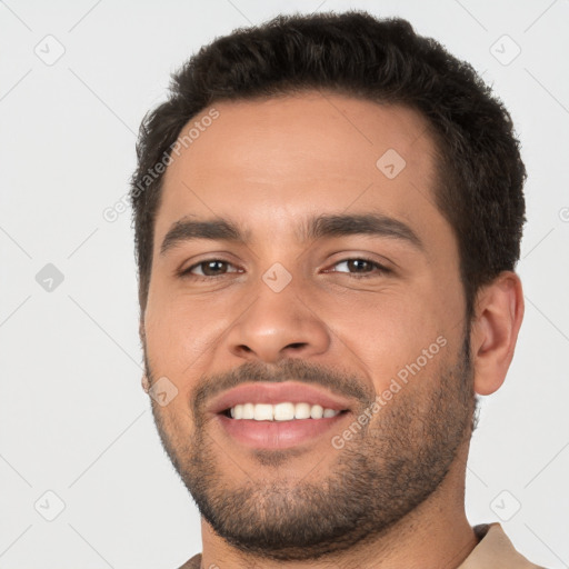 Joyful white young-adult male with short  black hair and brown eyes