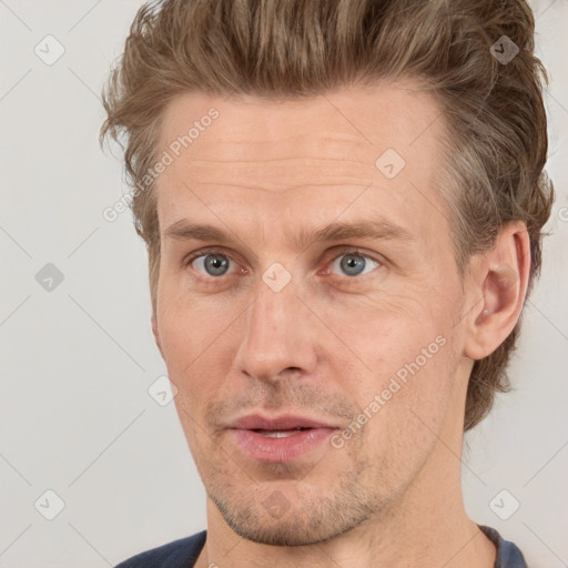 Joyful white adult male with short  brown hair and grey eyes