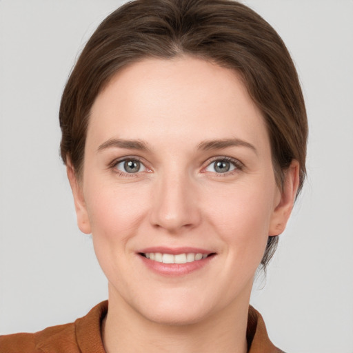 Joyful white young-adult female with short  brown hair and grey eyes