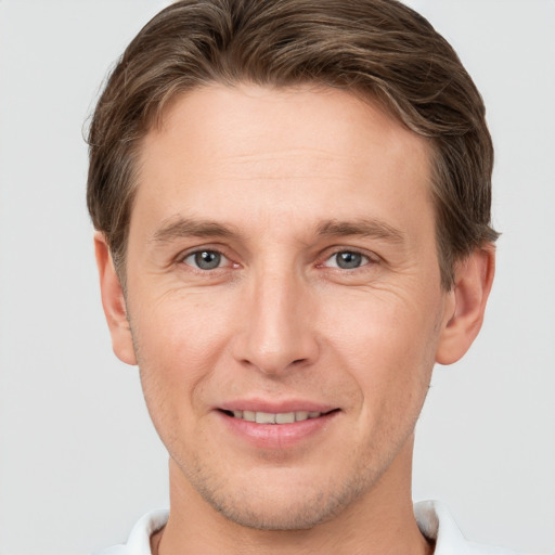 Joyful white young-adult male with short  brown hair and grey eyes