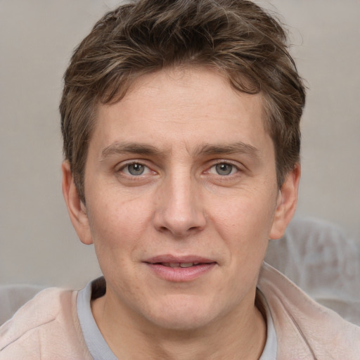 Joyful white adult male with short  brown hair and grey eyes