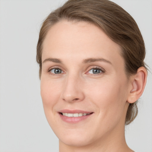 Joyful white young-adult female with medium  brown hair and green eyes