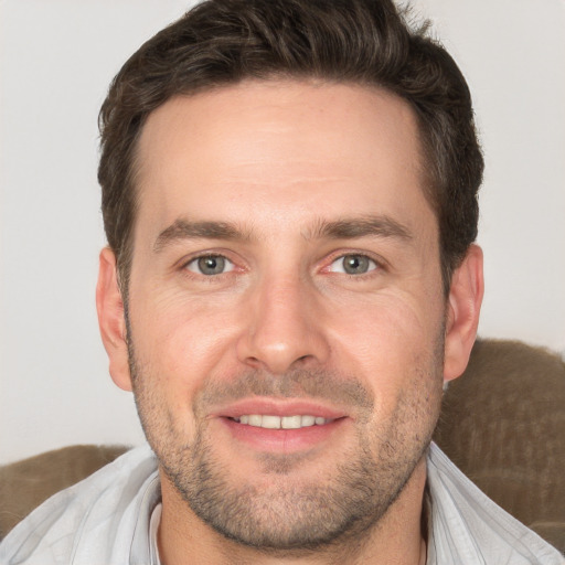 Joyful white adult male with short  brown hair and brown eyes