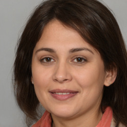 Joyful white adult female with medium  brown hair and brown eyes