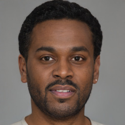 Joyful latino young-adult male with short  brown hair and brown eyes