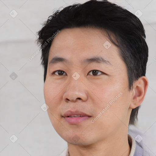 Joyful asian young-adult male with short  brown hair and brown eyes