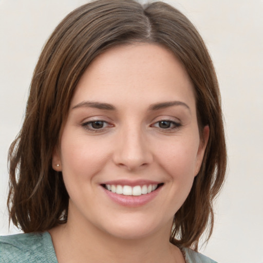 Joyful white young-adult female with medium  brown hair and green eyes