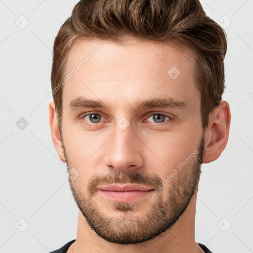 Joyful white young-adult male with short  brown hair and grey eyes