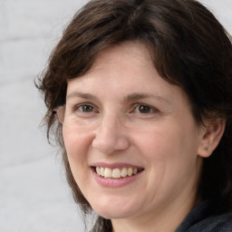 Joyful white adult female with medium  brown hair and grey eyes