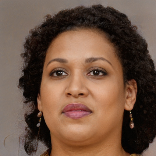 Joyful black young-adult female with long  brown hair and brown eyes